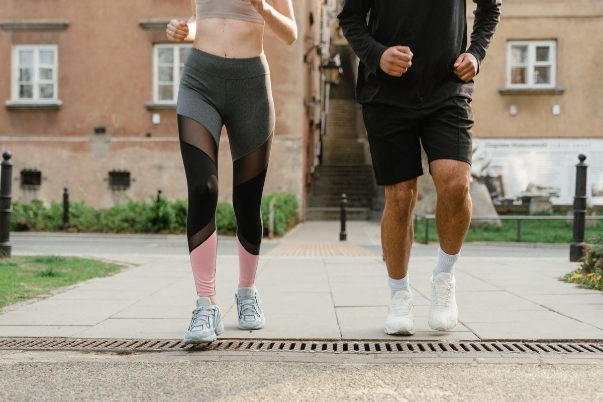 Two people jogging at a comfortable pace along a neighborhood path